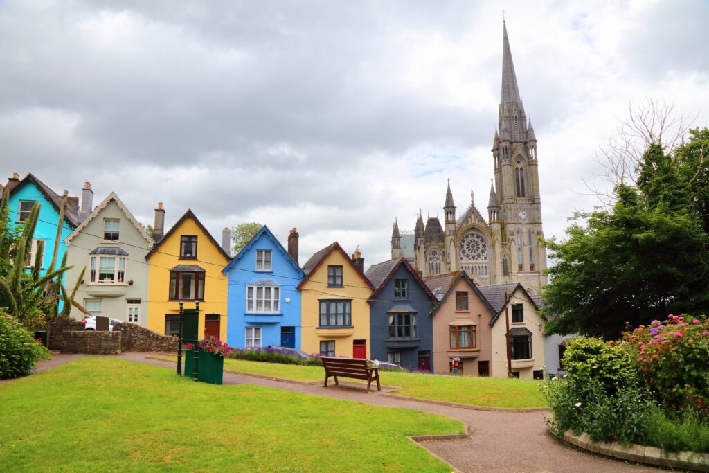 The 'Deck of Cards' houses on West View in Cobh, County Cork - the terrace of stepped, brightly painted homes that climbs the hill below St Colman's Cathedral. From the left the fronts run turquoise, cream, yellow, blue, plum-red and grey,
