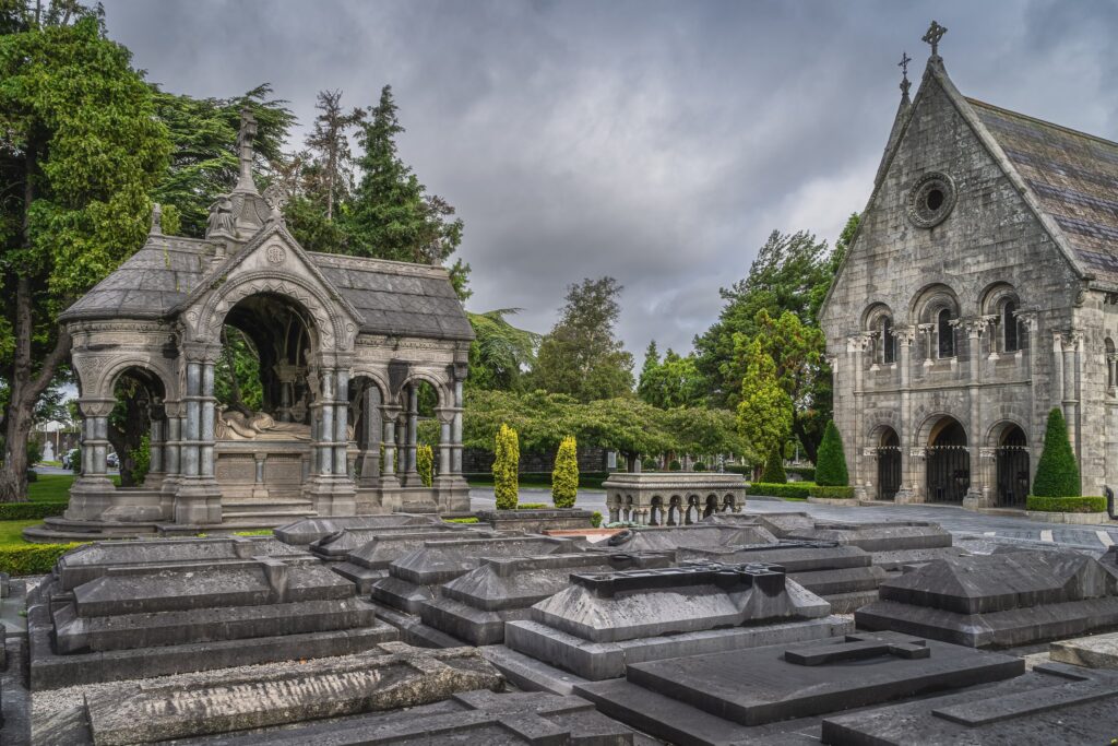 Historic stone chapel and Gothic church building with graves in foreground